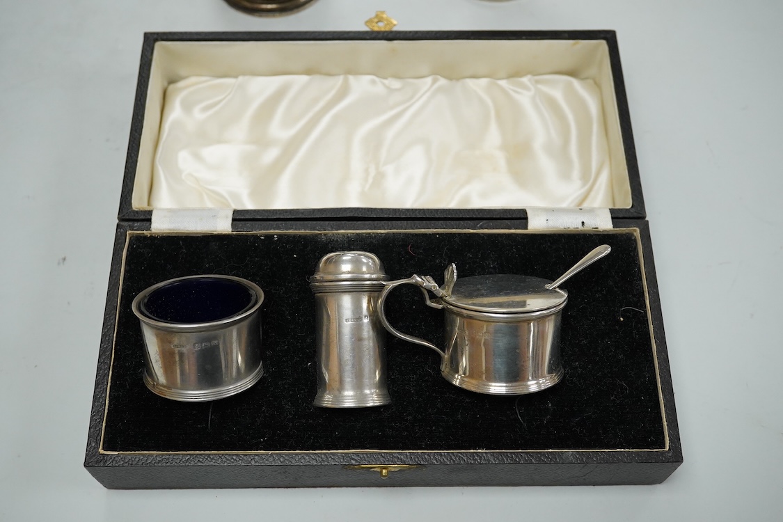 A George V silver tall cream jug, Birmingham, 1930, 17.2cm, a 1950's silver small mug, London, 1955 and a cased 1930's silver three piece condiment set.
